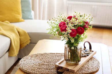 Photo of Beautiful ranunculus flowers and chamomiles in vase on table indoors. Space for text