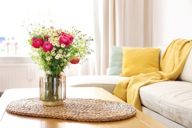 Photo of Beautiful ranunculus flowers and chamomiles in vase on table indoors. Space for text