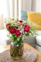 Photo of Beautiful ranunculus flowers and chamomiles in vase on table indoors