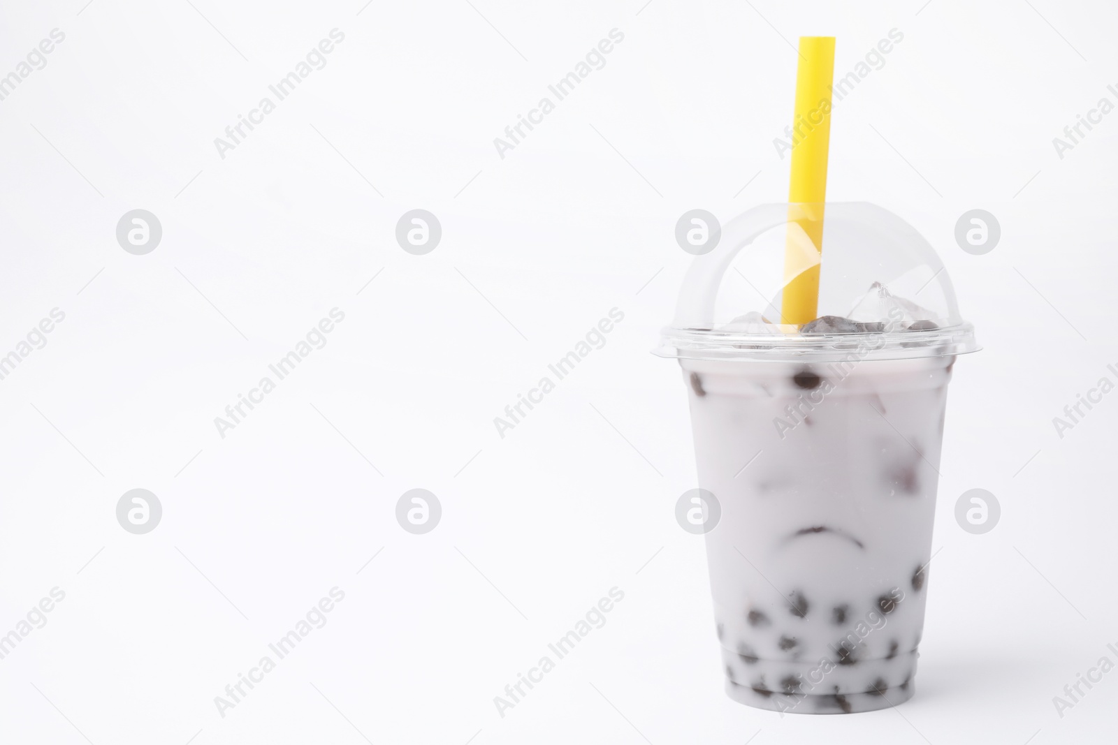 Photo of Tasty milk bubble tea in plastic cup on white background, space for text