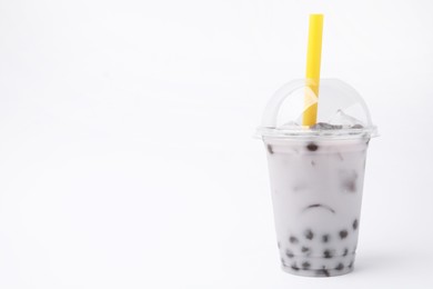 Photo of Tasty milk bubble tea in plastic cup on white background, space for text