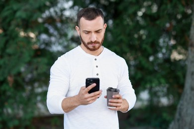 Photo of Handsome man using smartphone on blurred background