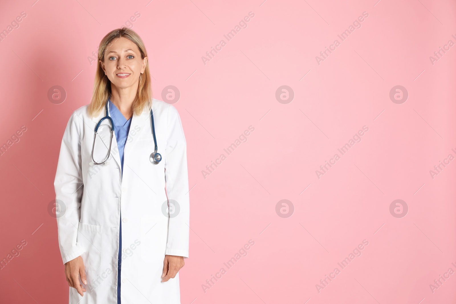 Photo of Portrait of doctor in medical uniform with stethoscope on pink background, space for text