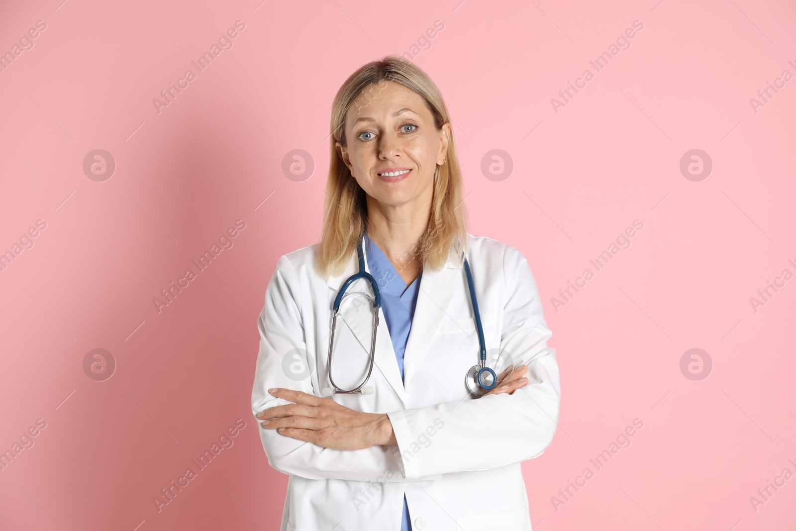 Photo of Portrait of doctor in medical uniform with stethoscope on pink background