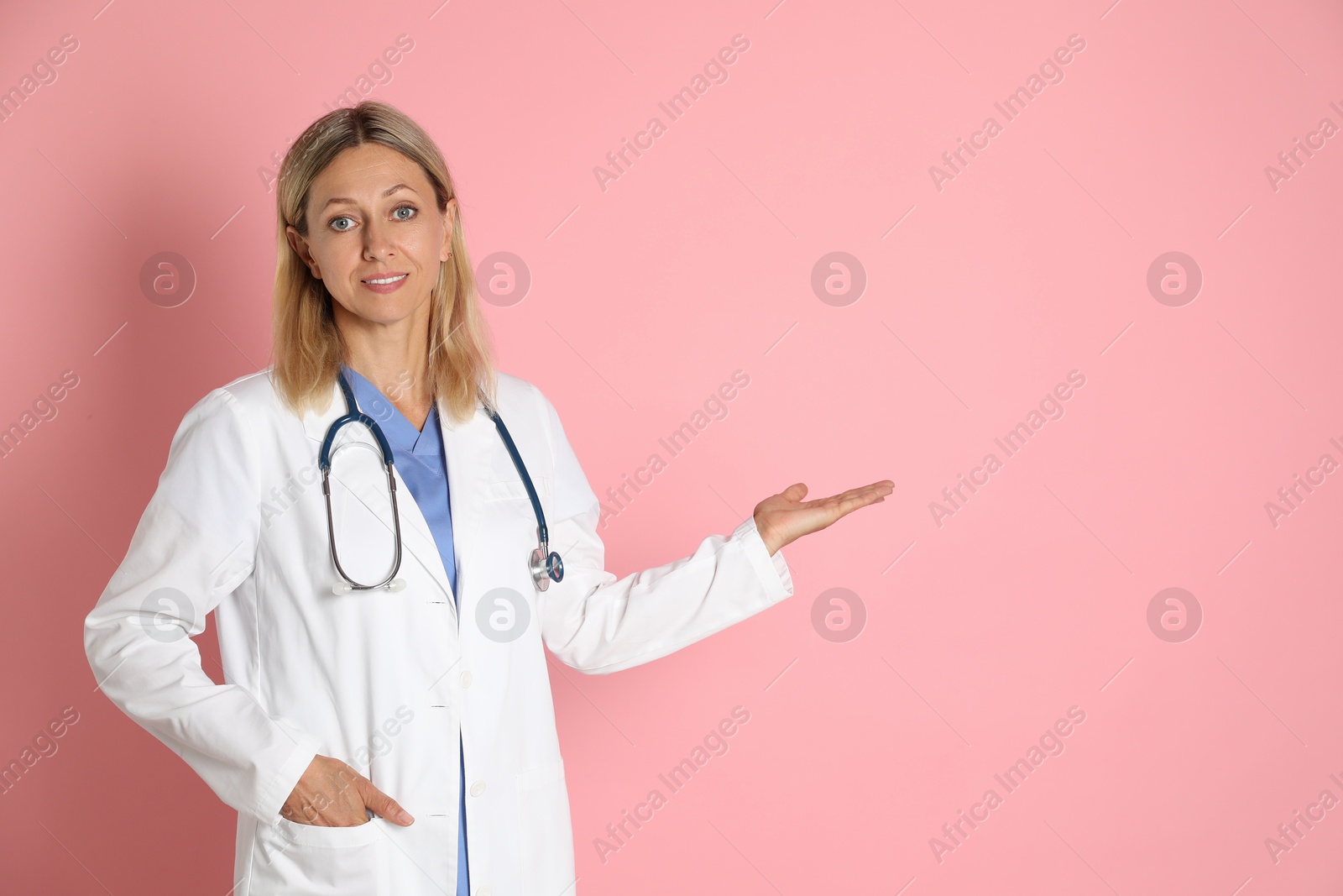 Photo of Portrait of doctor in medical uniform with stethoscope on pink background, space for text