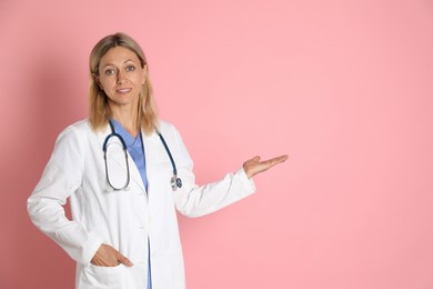 Photo of Portrait of doctor in medical uniform with stethoscope on pink background, space for text