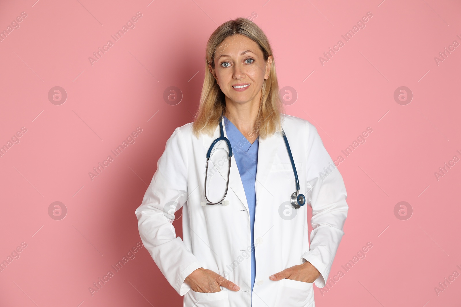 Photo of Portrait of doctor in medical uniform with stethoscope on pink background