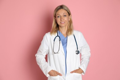 Portrait of doctor in medical uniform with stethoscope on pink background