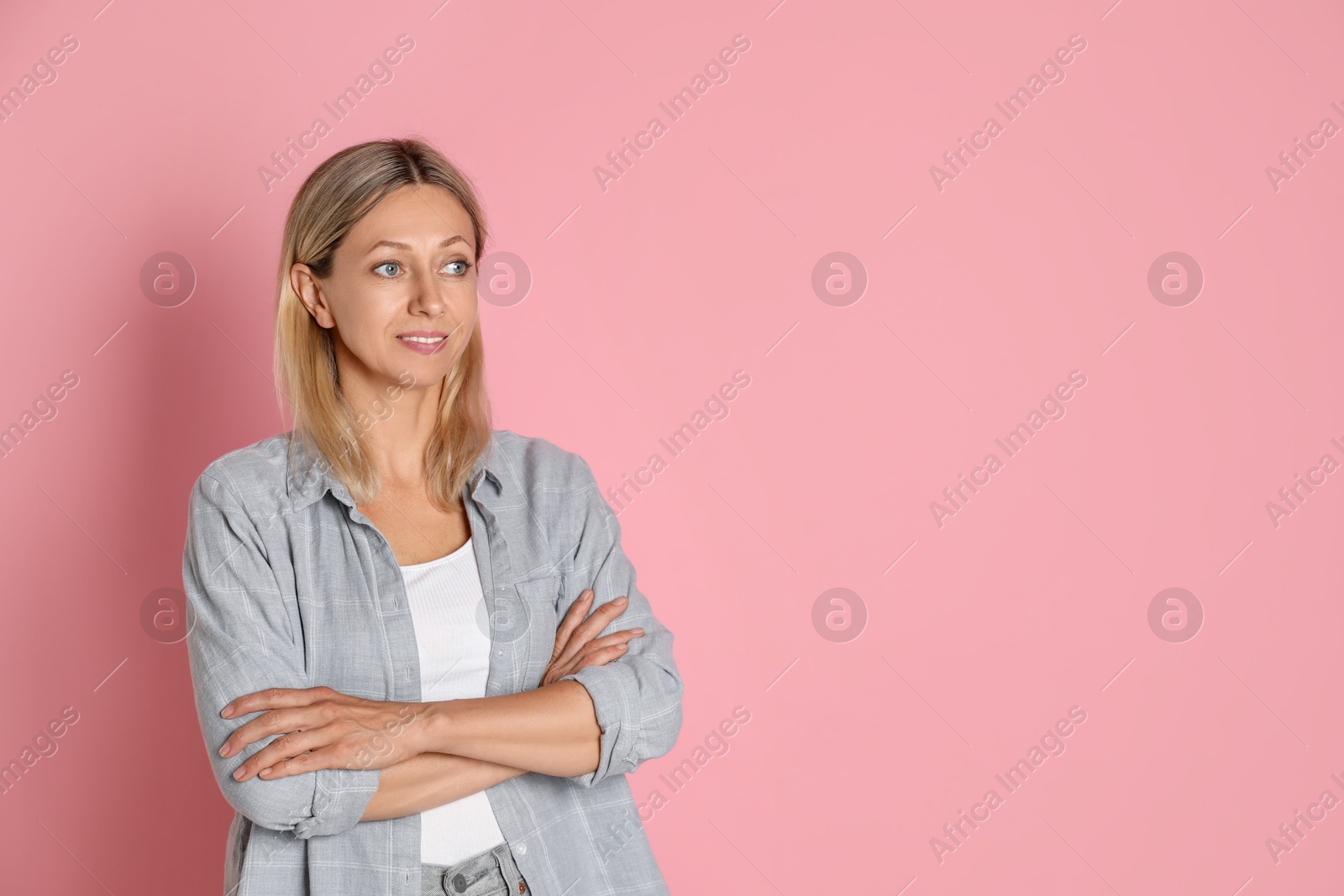 Photo of Beautiful smiling woman on pink background, space for text