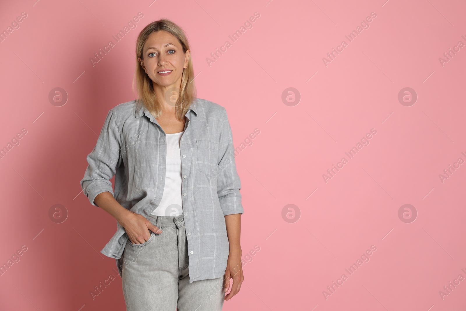 Photo of Portrait of beautiful smiling woman on pink background, space for text