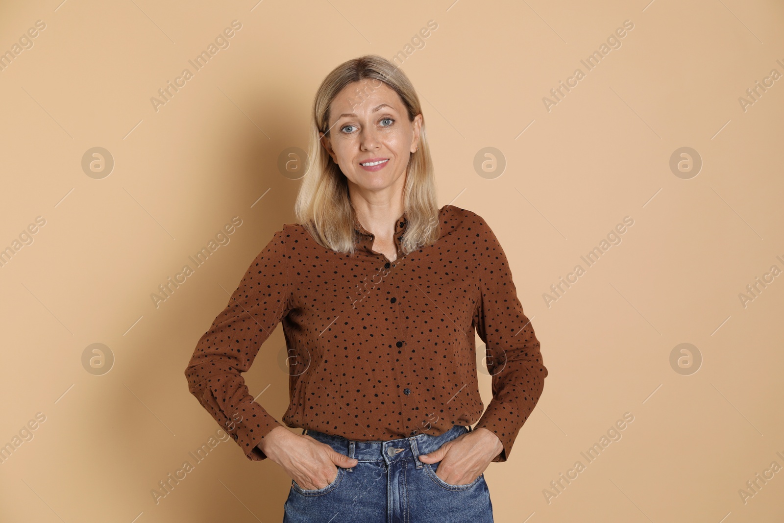 Photo of Portrait of beautiful smiling woman on beige background