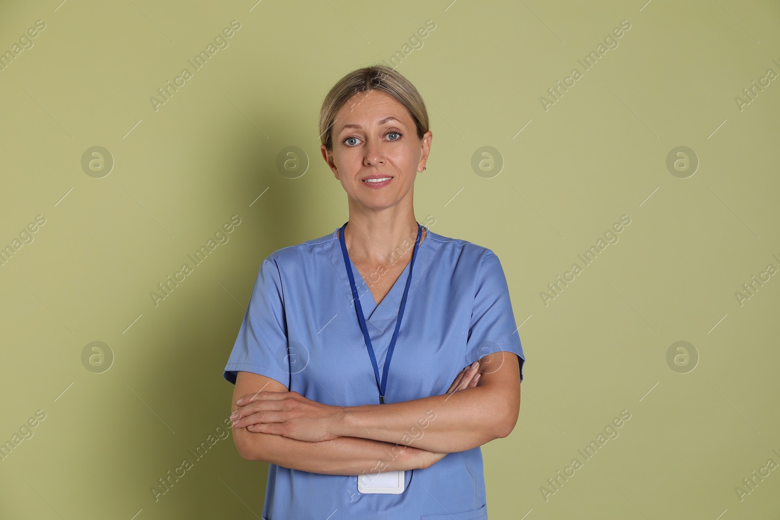 Photo of Portrait of nurse in medical uniform with badge on light green background