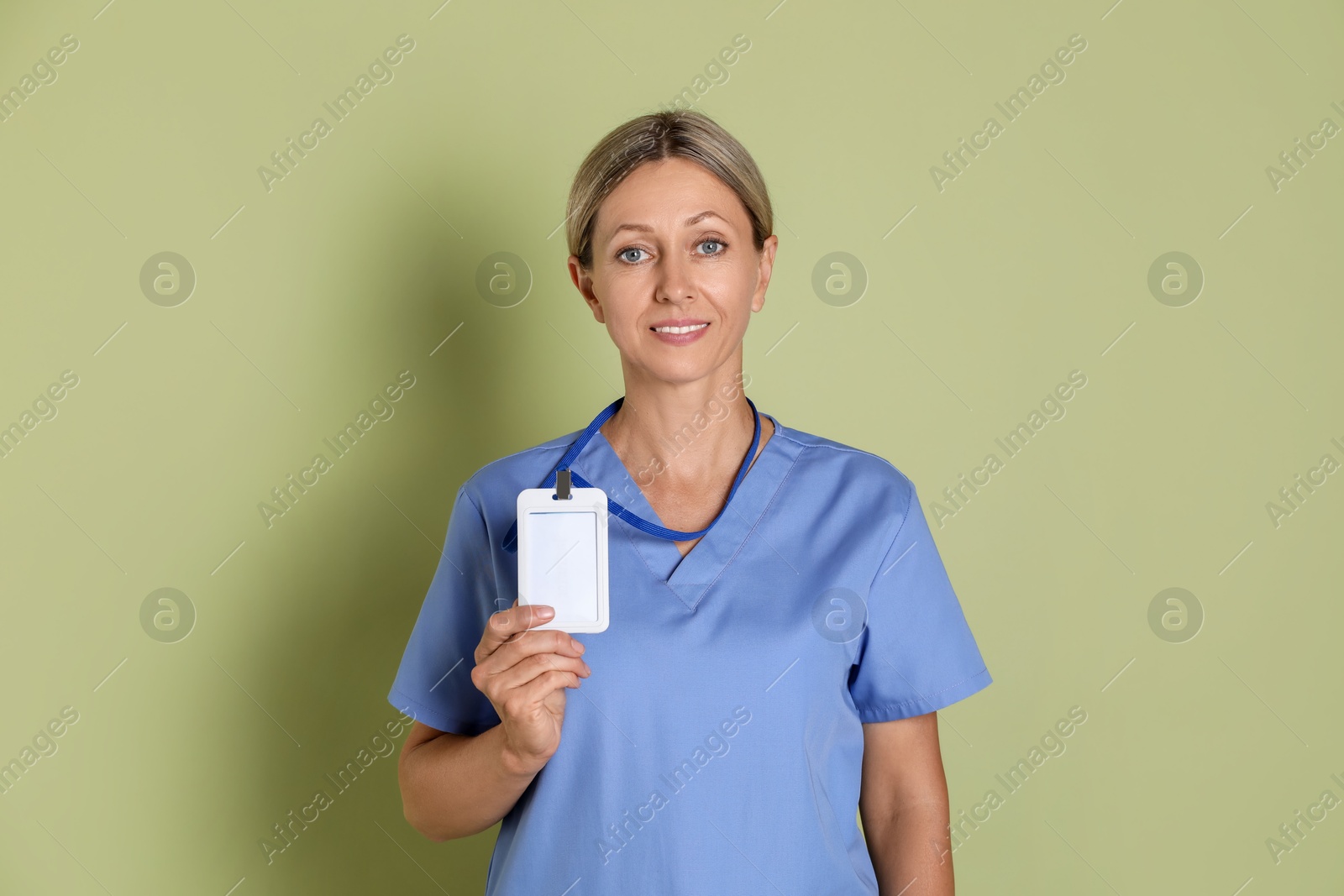 Photo of Portrait of nurse in medical uniform with badge on light green background