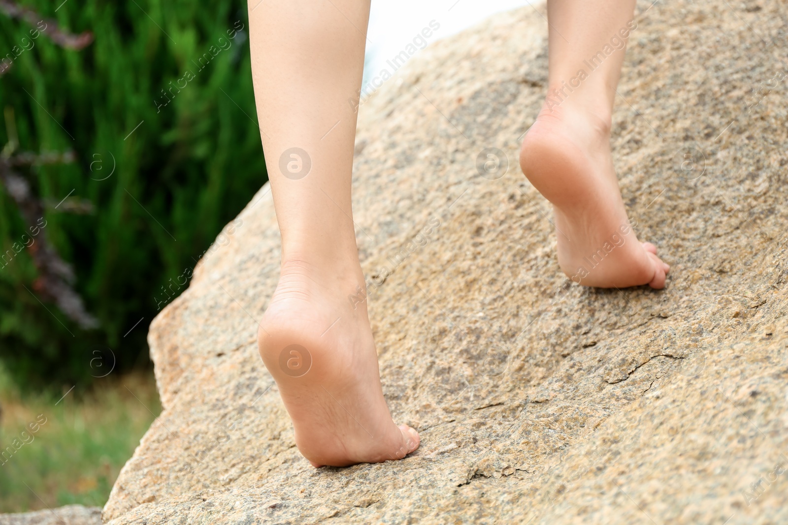 Photo of Woman standing barefoot on rock outdoors, closeup