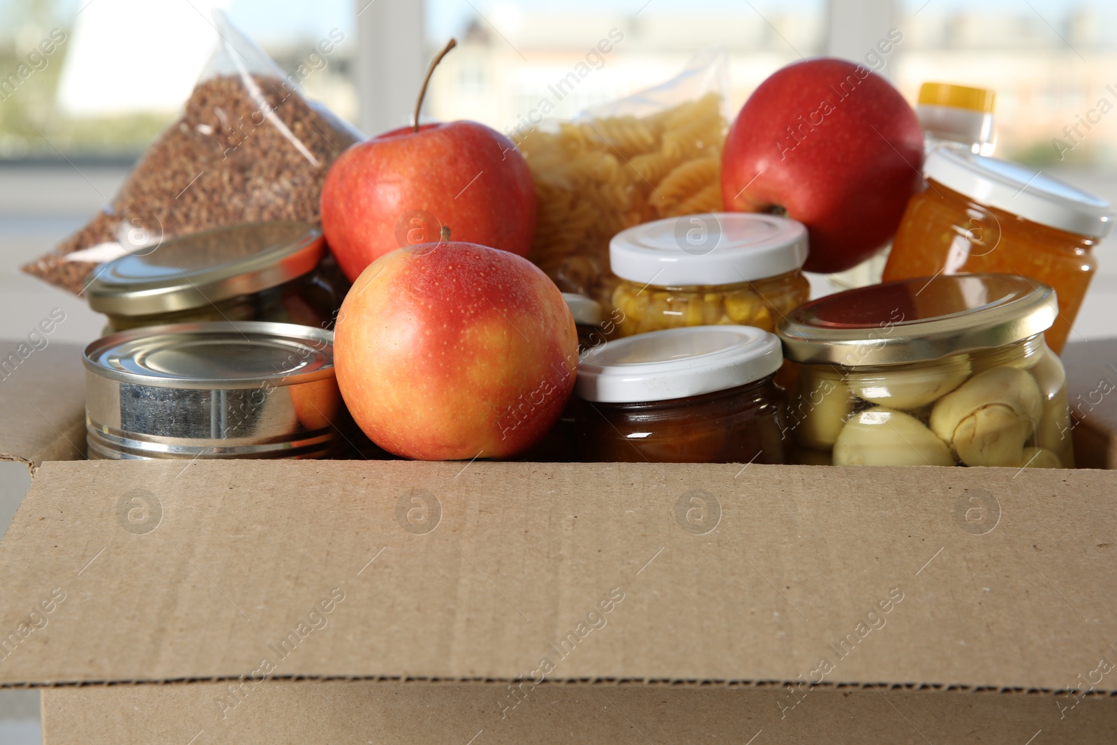 Photo of Different food products for donation in box indoors, closeup