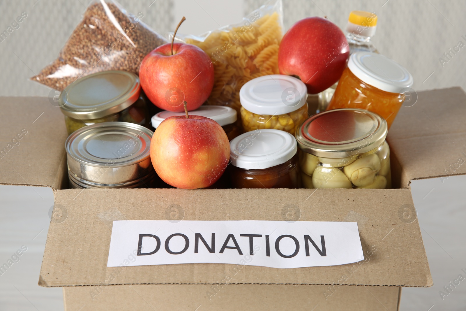 Photo of Different food products for donation in box indoors, closeup