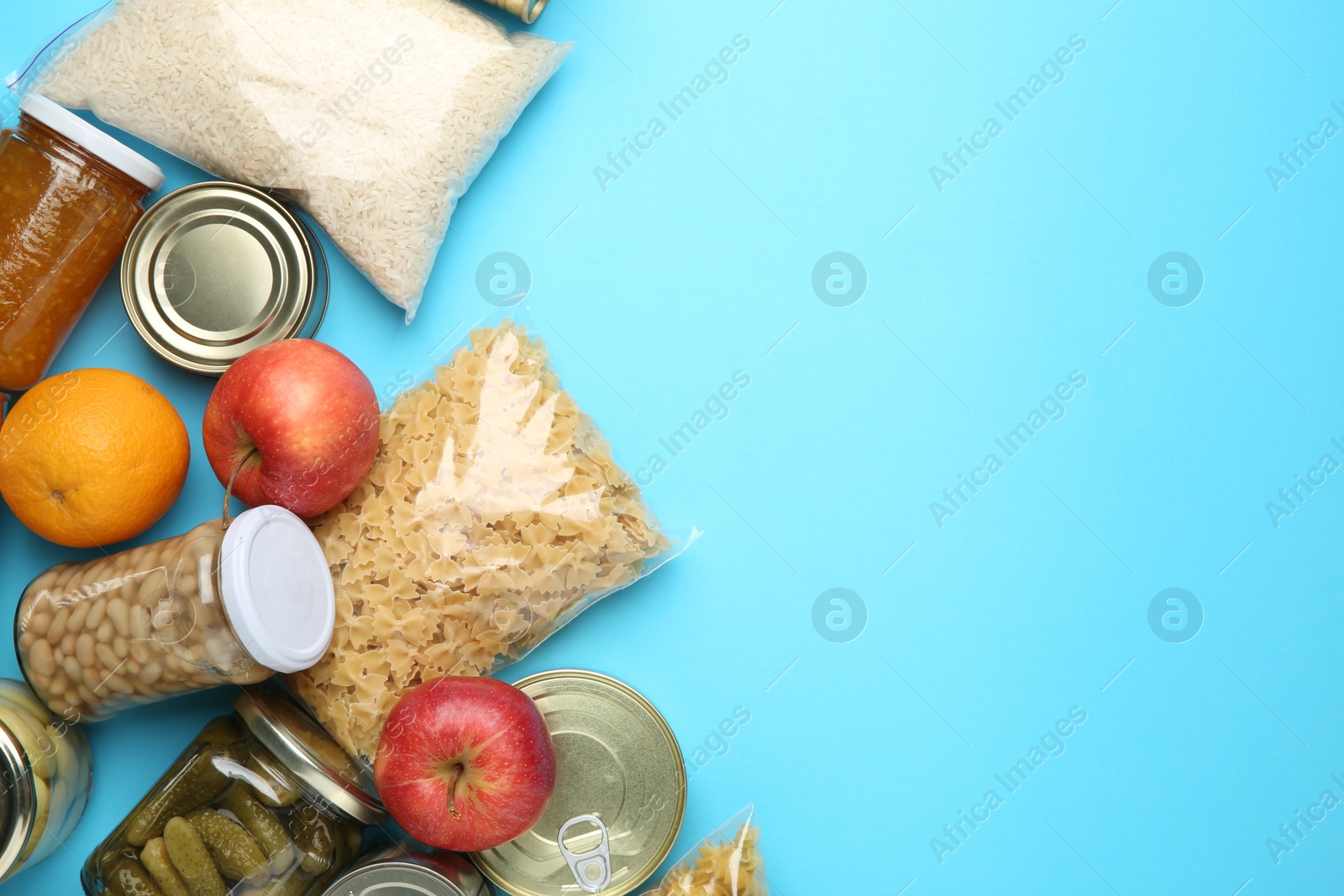 Photo of Food donation. Different products on light blue background, flat lay. Space for text