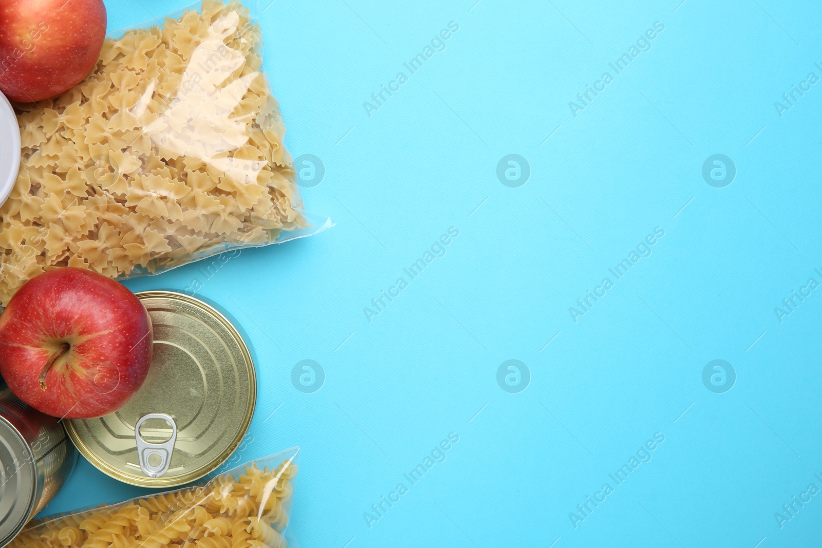 Photo of Food donation. Different products on light blue background, flat lay. Space for text