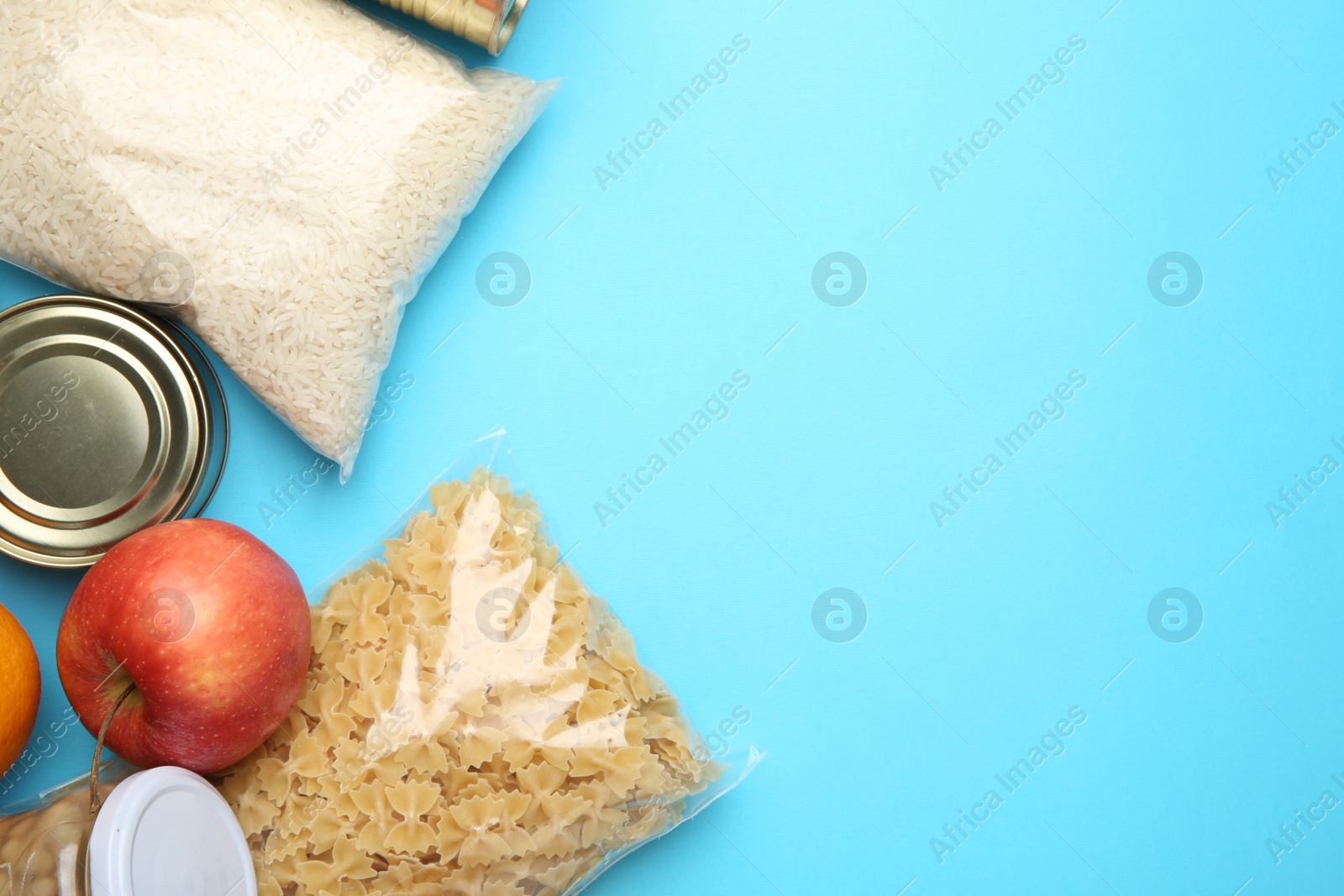 Photo of Food donation. Different products on light blue background, flat lay. Space for text