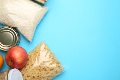 Photo of Food donation. Different products on light blue background, flat lay. Space for text