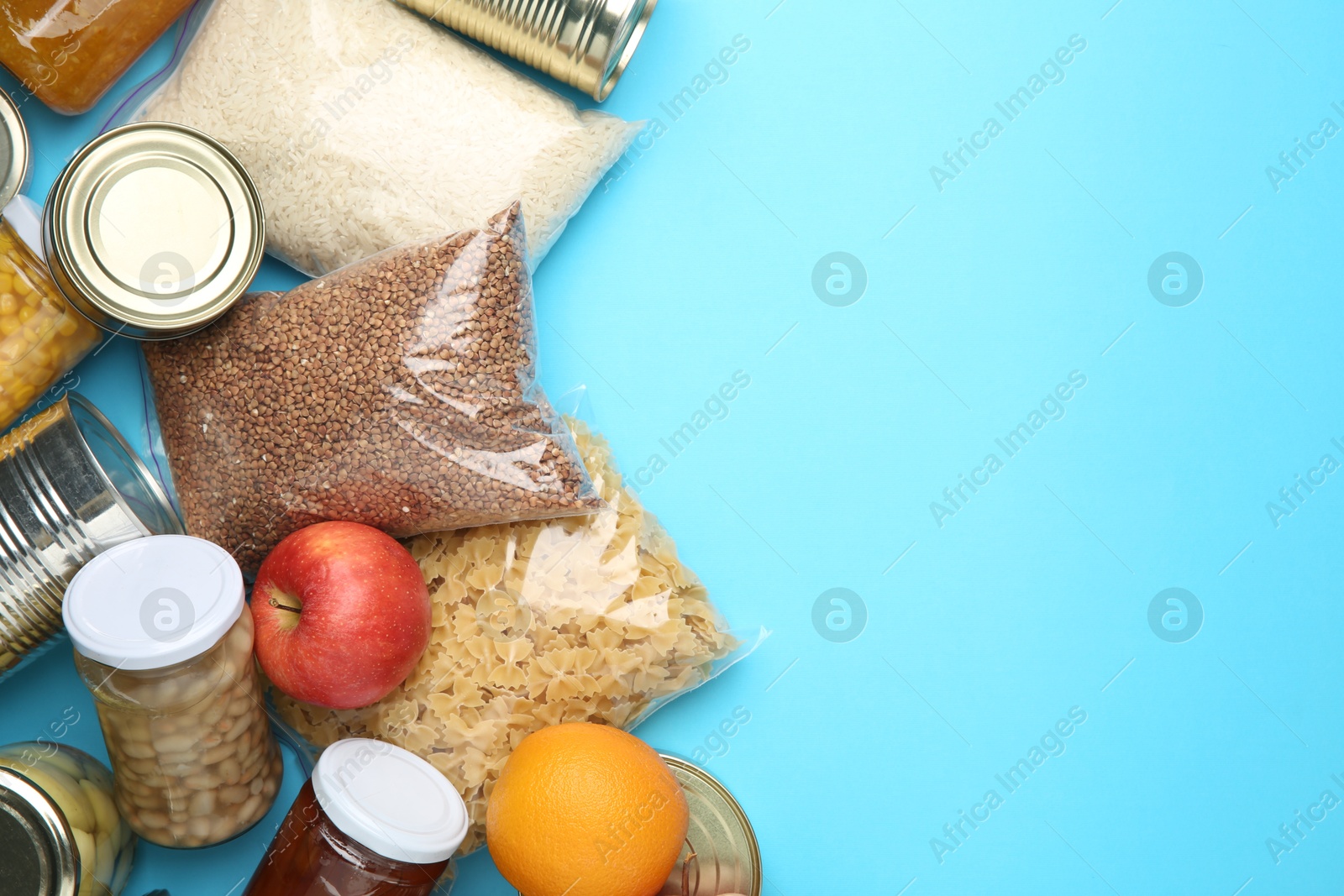 Photo of Food donation. Different products on light blue background, flat lay. Space for text