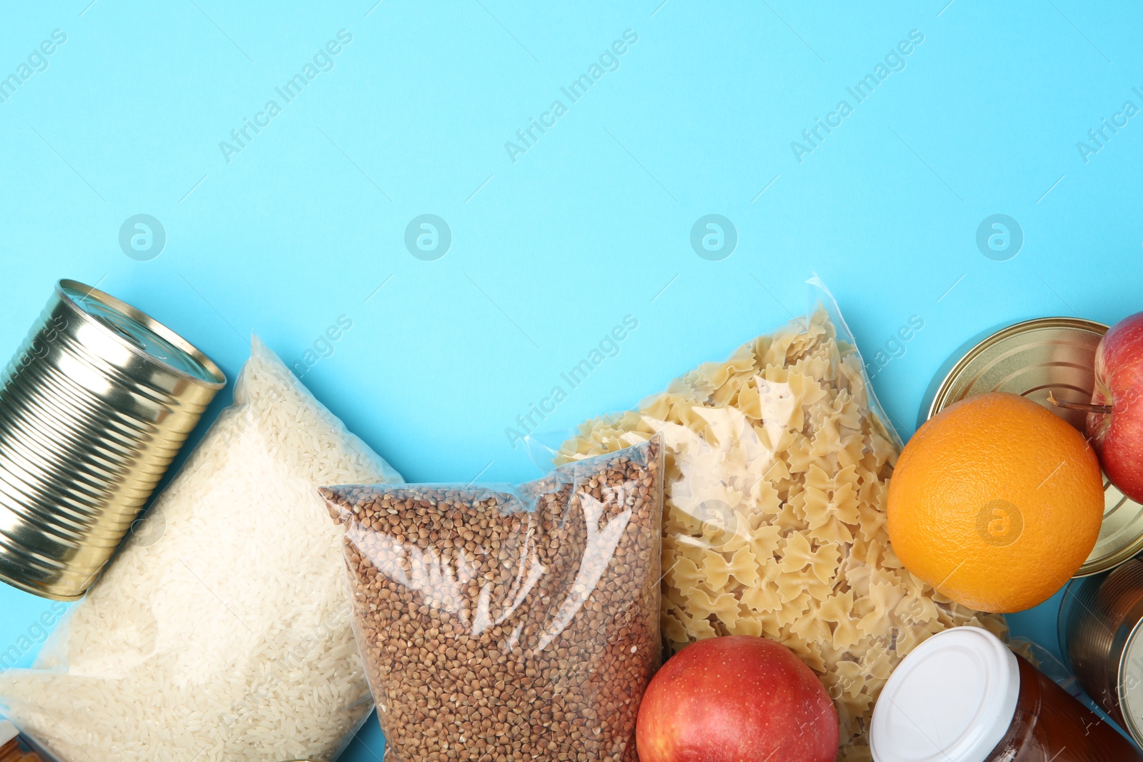 Photo of Food donation. Different products on light blue background, flat lay. Space for text