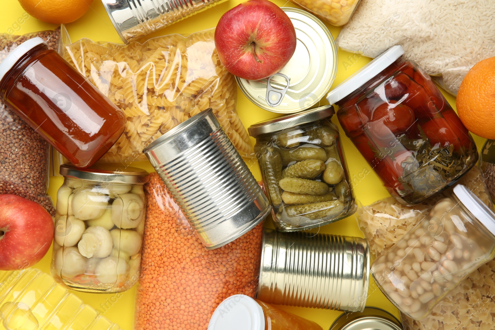 Photo of Food donation. Different products on yellow background, top view