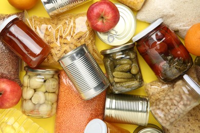 Photo of Food donation. Different products on yellow background, top view