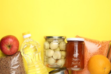 Photo of Food donation. Different products on yellow background, flat lay. Space for text