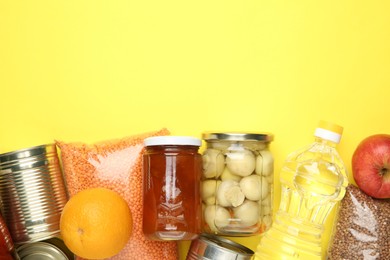 Photo of Food donation. Different products on yellow background, flat lay. Space for text