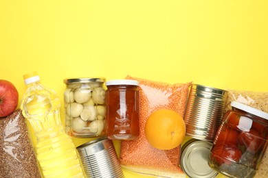 Photo of Food donation. Different products on yellow background, flat lay. Space for text