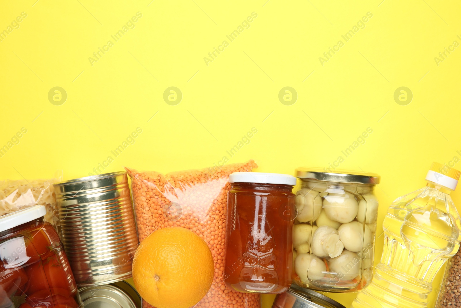 Photo of Food donation. Different products on yellow background, flat lay. Space for text