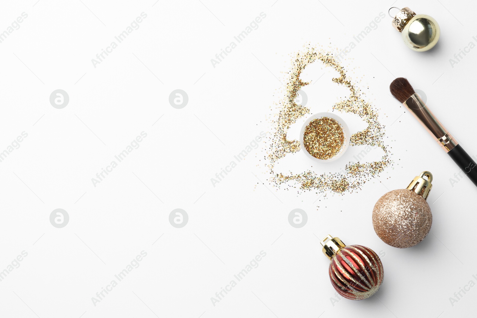 Photo of Christmas tree made of glitter, balls and makeup brush on white background, flat lay. Space for text