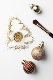 Photo of Christmas tree made of glitter, balls and makeup brush on white background, flat lay