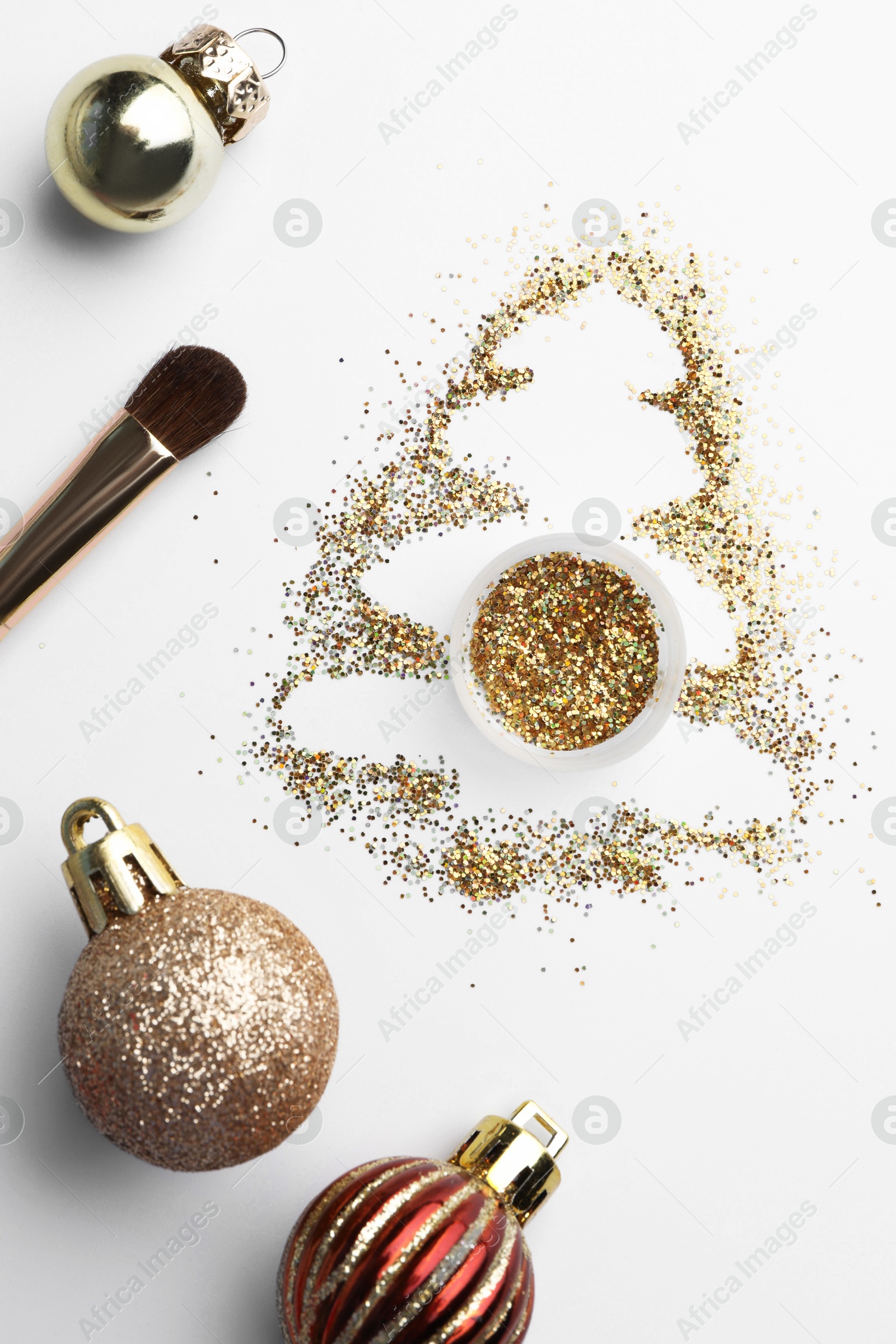 Photo of Christmas tree made of glitter, balls and makeup brush on white background, flat lay