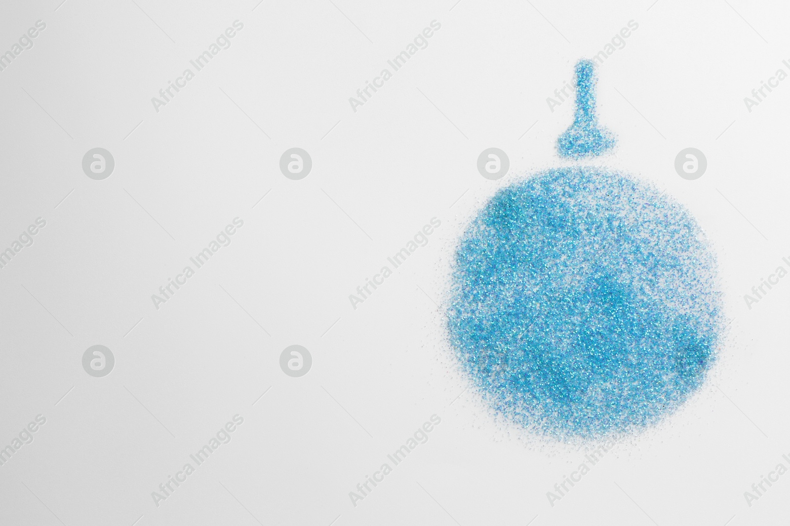 Photo of Christmas ball made of light blue glitter on white background, top view. Space for text