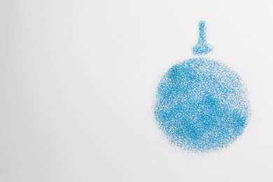 Photo of Christmas ball made of light blue glitter on white background, top view. Space for text