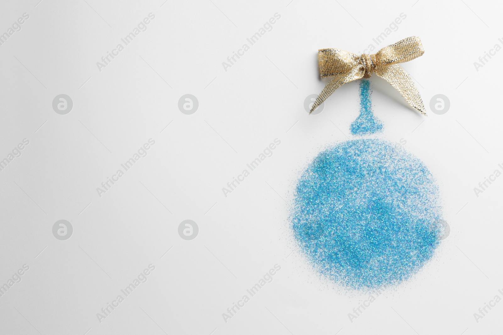 Photo of Christmas ball made of light blue glitter with bow on white background, top view. Space for text