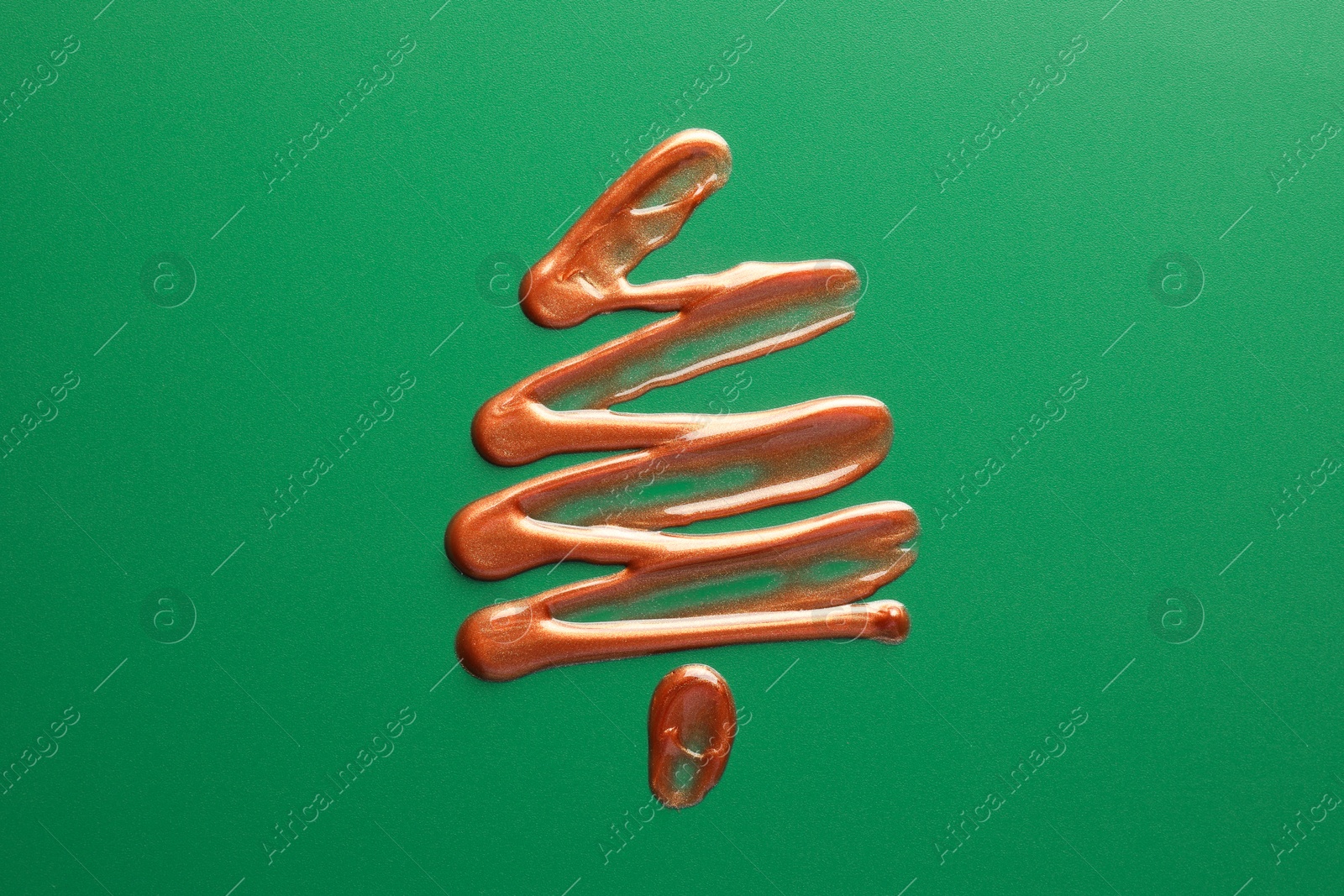 Photo of Christmas tree drawn of cosmetic product on green background, top view