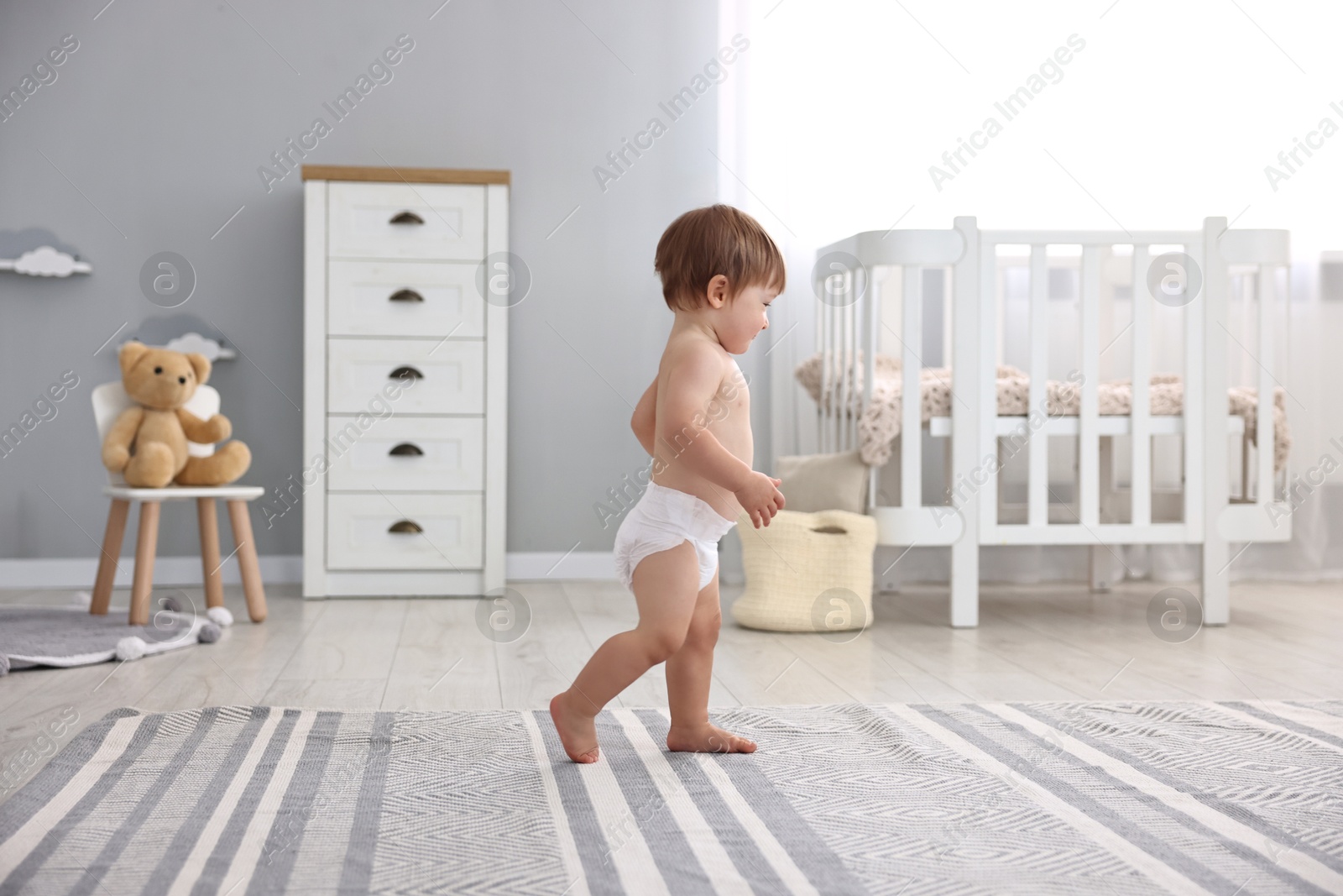 Photo of Cute little child in diaper at home