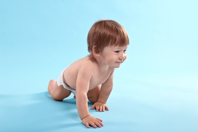 Photo of Cute little child in diaper on light blue background