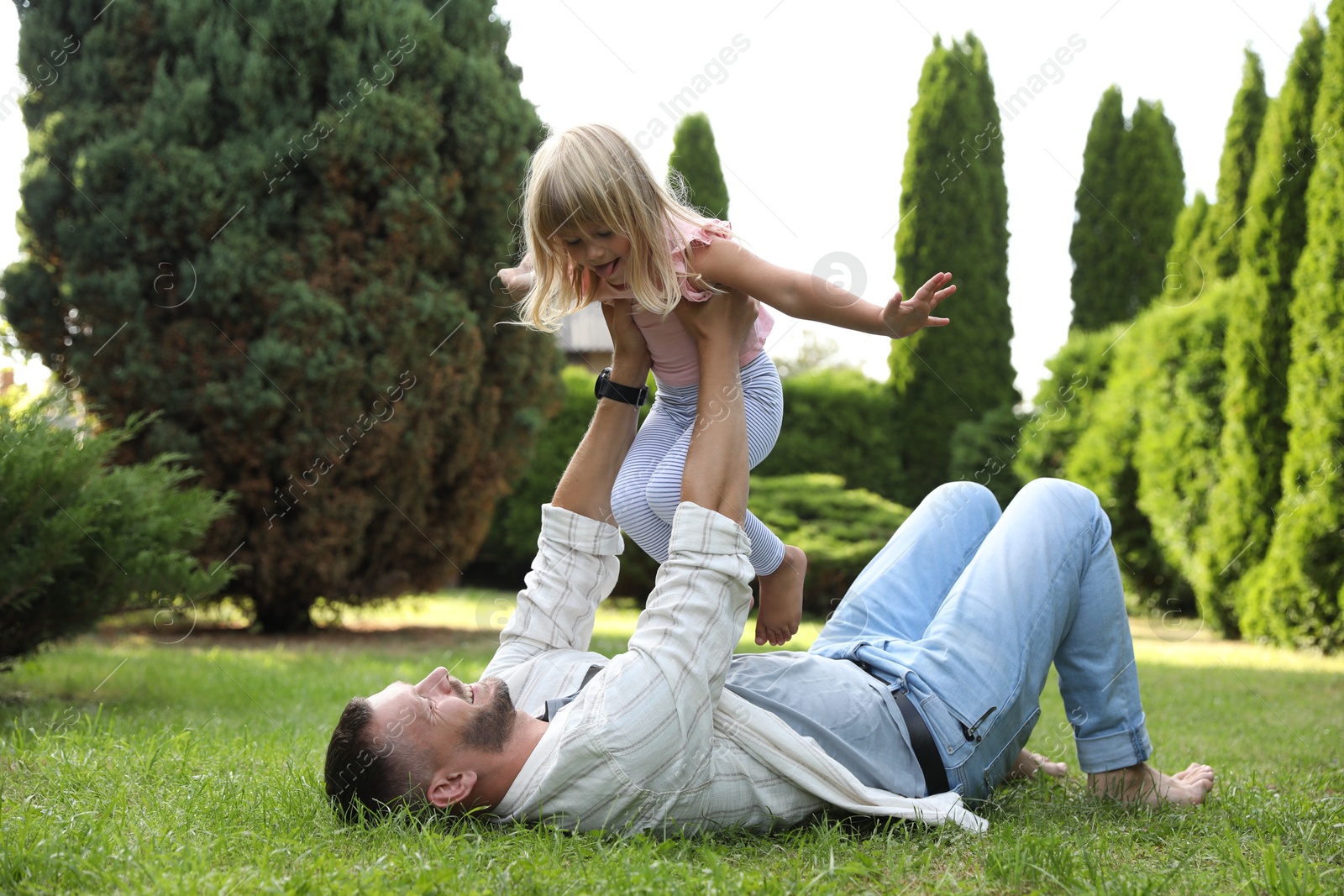 Photo of Father and his daughter spending time together on green lawn in park