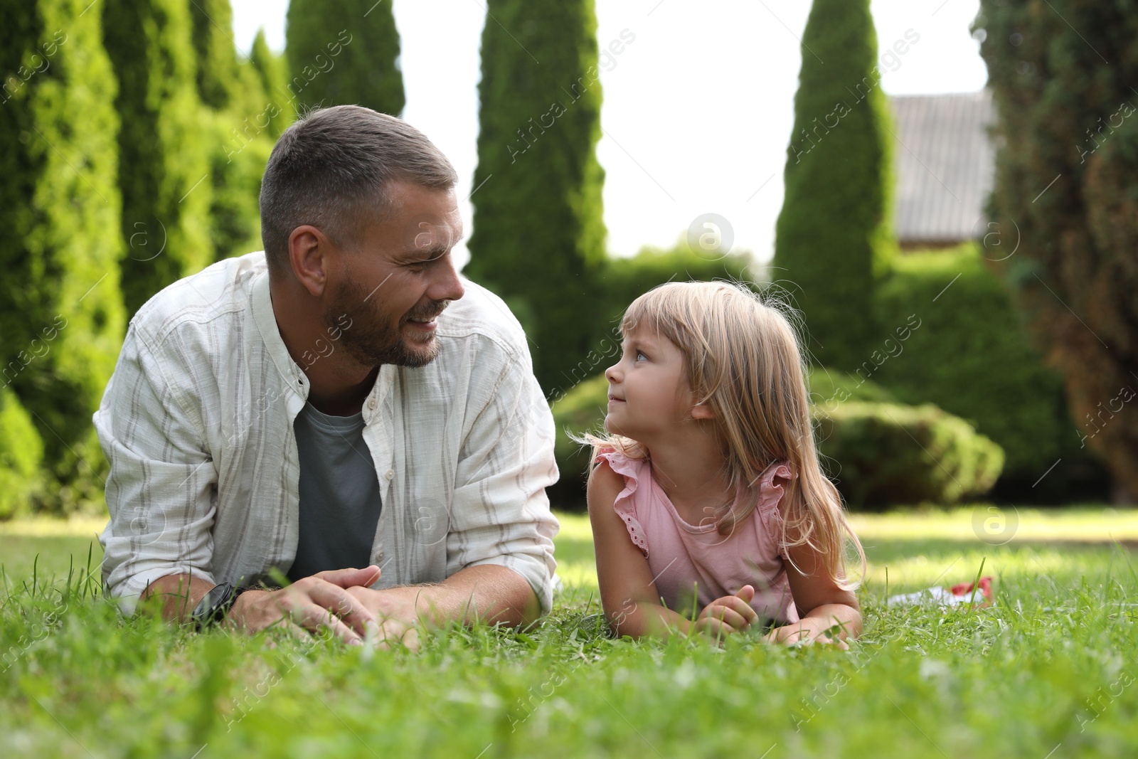 Photo of Father and his daughter spending time together on green lawn in park