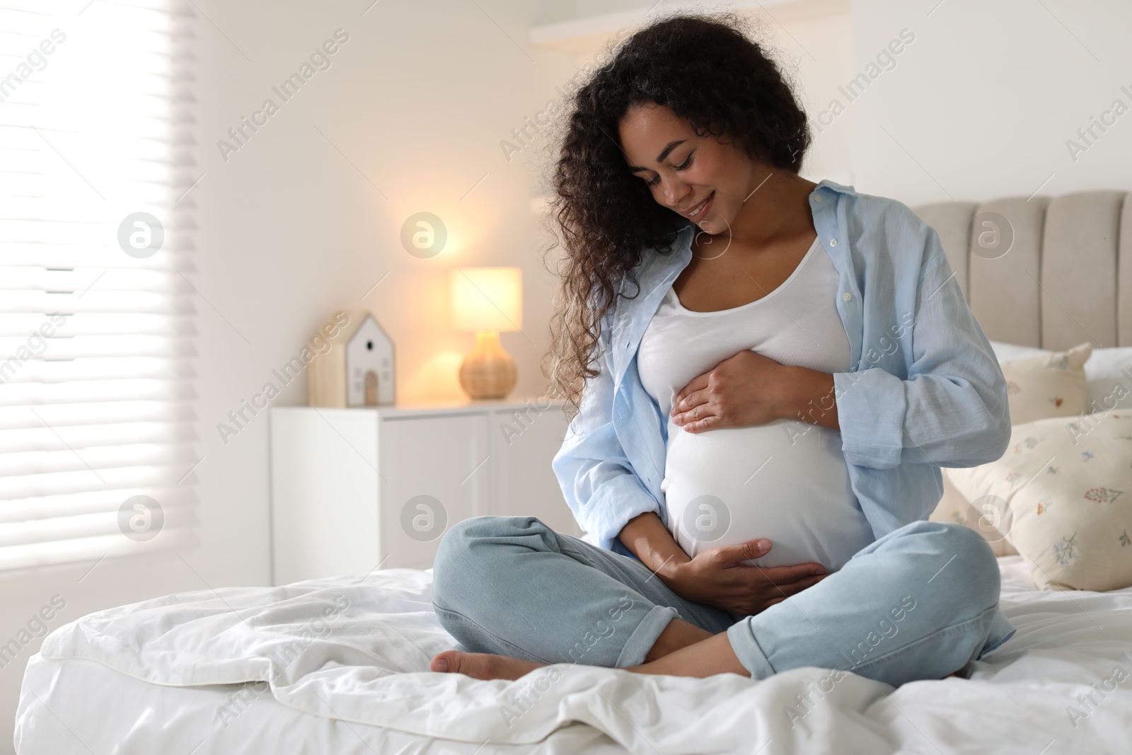 Photo of Portrait of beautiful pregnant woman on bed at home