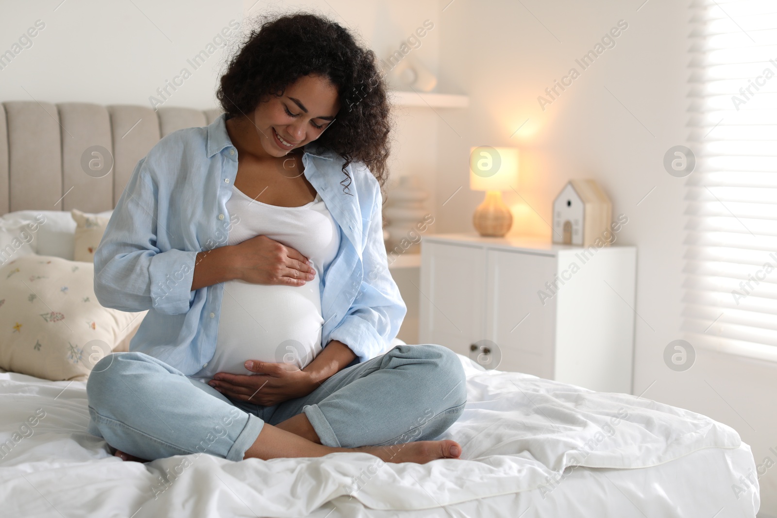 Photo of Portrait of beautiful pregnant woman on bed at home