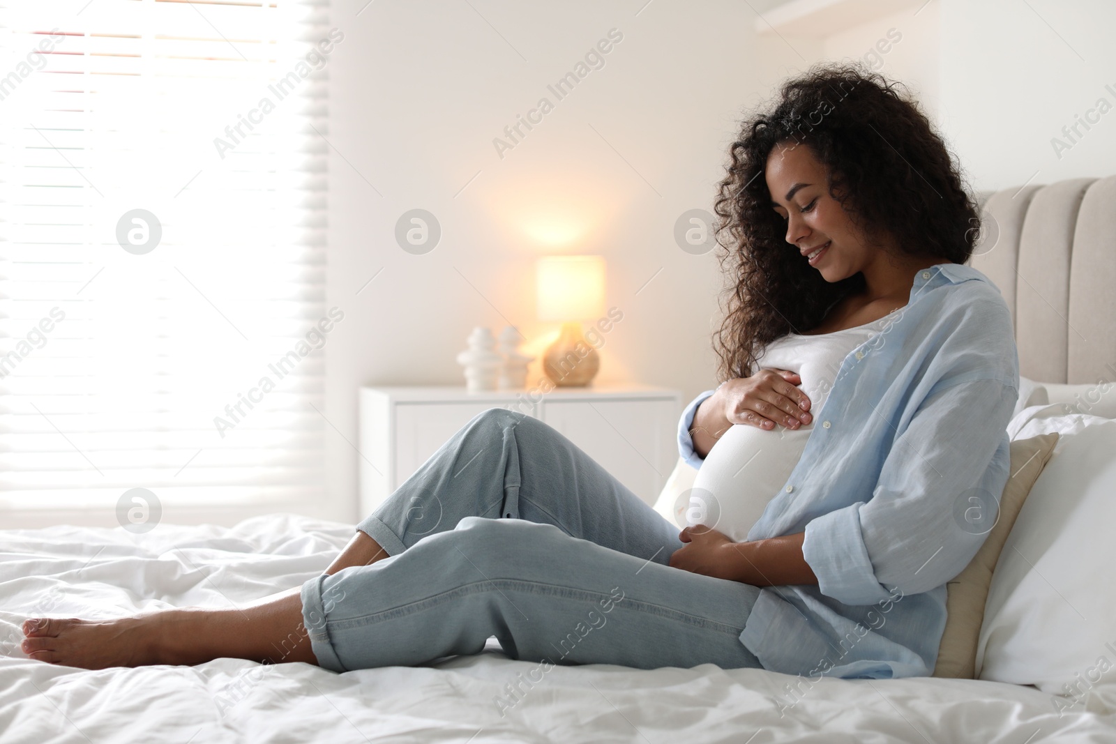 Photo of Portrait of beautiful pregnant woman on bed at home