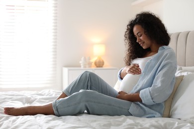 Photo of Portrait of beautiful pregnant woman on bed at home