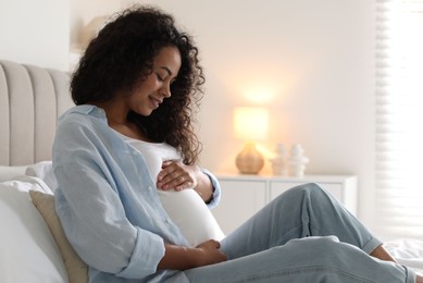 Portrait of beautiful pregnant woman on bed at home