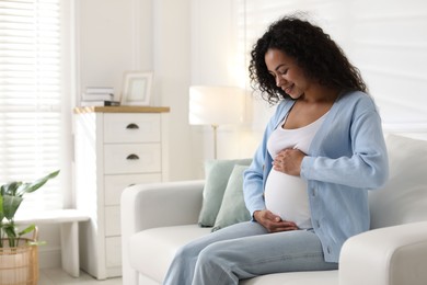 Photo of Portrait of beautiful pregnant woman on sofa at home