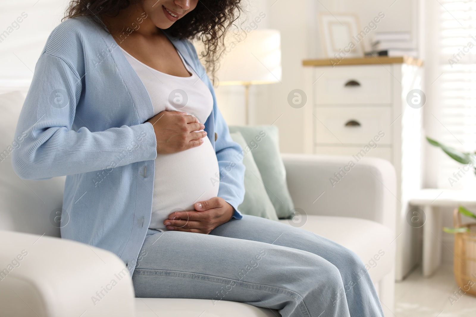 Photo of Pregnant woman on sofa at home, closeup